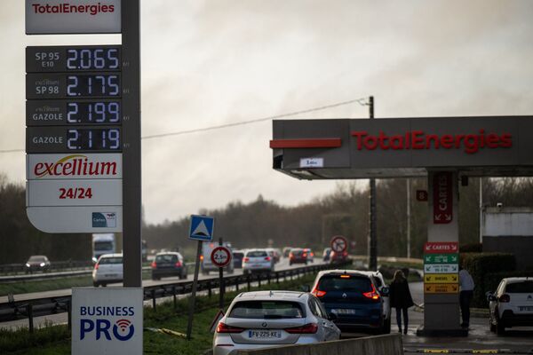 O fotografie făcută pe 8 martie 2022 în Temple-de-Bretagne în care se poate vedea o coadă de mașini și afișajul care indică prețul combustibilului la benzinăria din această localitate.  - Sputnik Moldova-România