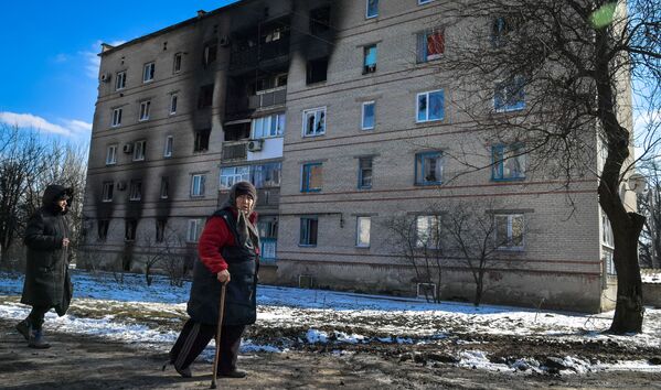 Femei în apropierea unei case avariate de bombardamente în microdistrictul Severnâi din Volnovaha. - Sputnik Moldova