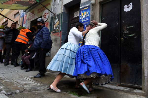 Борцы &quot;чолиты&quot; устраивают представление на улице в Ла-Пасе, Боливия, 12 марта 2022 года. - Sputnik Молдова