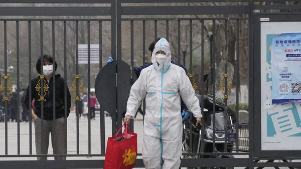 Мужчина в защитном костюме с сумкой из закрытого микрорайона в Пекине  - Sputnik Молдова
