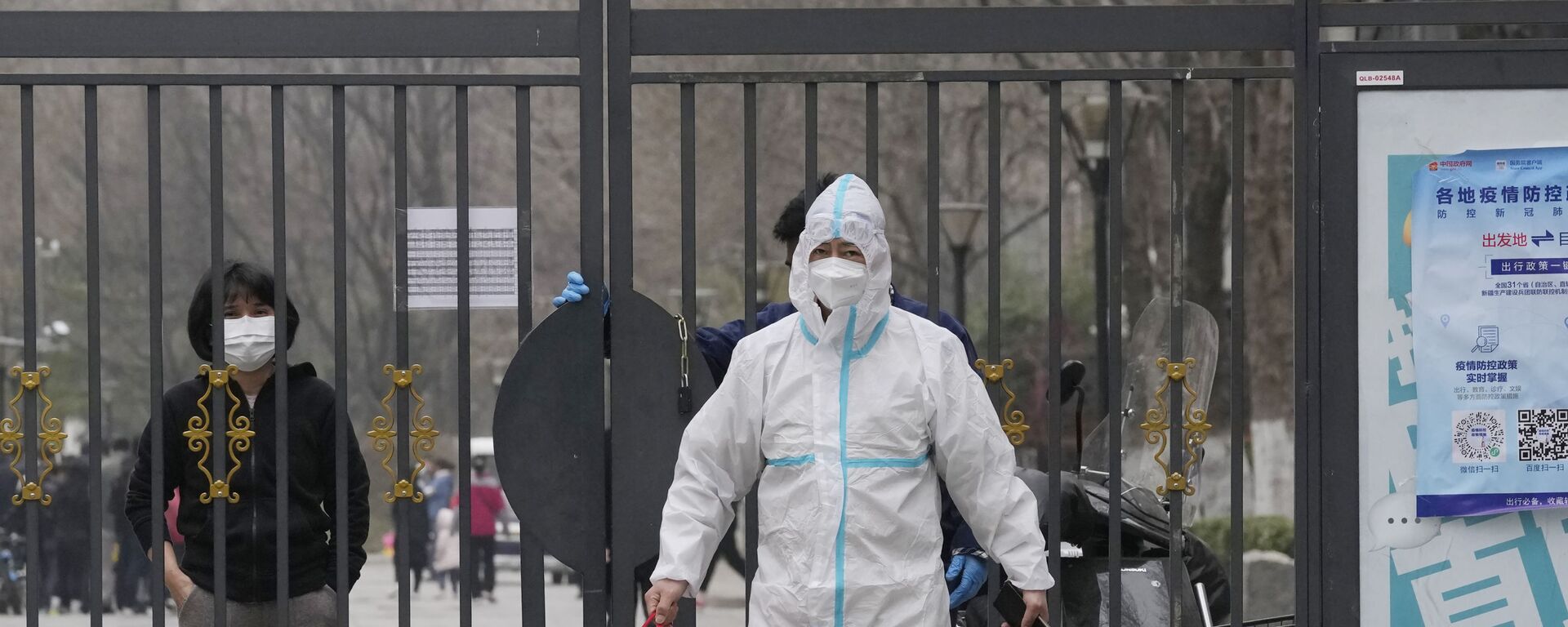 Мужчина в защитном костюме с сумкой из закрытого микрорайона в Пекине  - Sputnik Молдова, 1920, 27.11.2022
