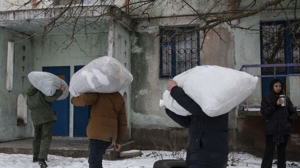 Местные жители помогают военнослужащим Народной милиции ЛНР выгружать мешки с гуманитарной помощью в освобожденном селе Теплое - Sputnik Moldova-România