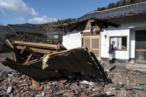 Producătorul de sushi Akio Hanzawa pășește în fața restaurantului său avariat din Shiroishi, prefectura Miyagi, pe 17 martie 2022, după ce un cutremur cu magnitudinea de 7,3 a zguduit estul Japoniei cu o seară înainte. - Sputnik Moldova-România