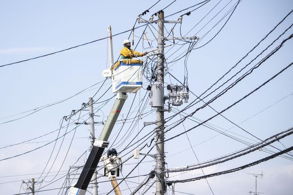Рабочий проводит электромонтажные работы после отключения электроэнергии в Соме, префектура Фукусима, 17 марта 2022 года, после землетрясения силой 7,3 балла, которое произошло накануне вечером на востоке Японии. - Sputnik Молдова