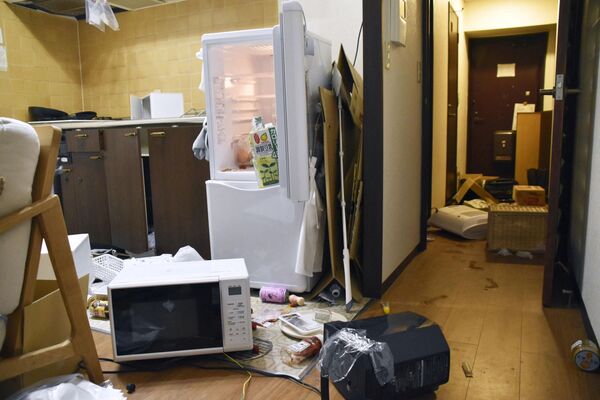 Мебель и электроприборы разбросаны в результате землетрясения в квартире в Фукусиме, Япония, 16 марта 2022 года. - Sputnik Молдова