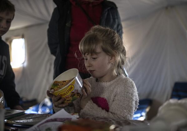 O fată examinează o cutie de Rollton într-o tabără de corturi din Starobelsk. - Sputnik Moldova