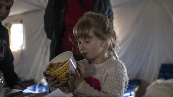 Девочка рассматривает банку с Роллтоном в палаточном лагере в Старобельске - Sputnik Moldova