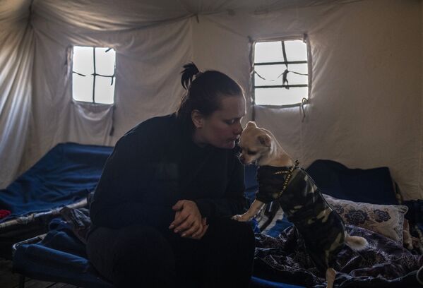 O femeie cu un câine în tabăra de corturi din Starobilsk. - Sputnik Moldova