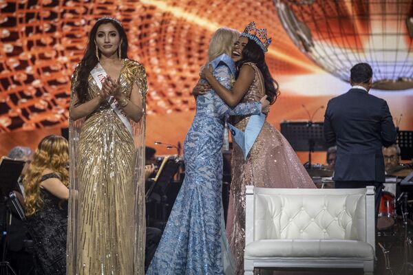 Miss World 2019 Toni-Ann Singh (în dreapta) o felicită pe Miss Polonia Karolina Bielawska (în centru) după ce a câștigat cel de-al 70-lea concurs de frumusețe Miss World la Coca-Cola Music Hall din San Juan, Puerto Rico, pe 16 martie 2022. - Sputnik Moldova-România