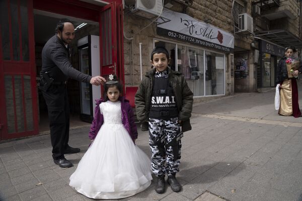 Ультраортодоксальный еврей поправляет корону на костюме своей дочери в Иерусалиме. - Sputnik Молдова