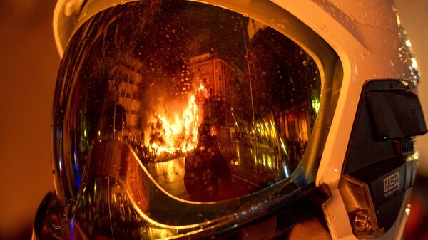 Пожарный во время сожжения деревянных фигур на празднике огня Фальяс в Валенсии - Sputnik Молдова