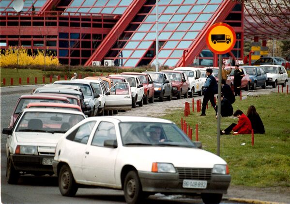 Șoferii se odihnesc lângă mașinile parcate în cozi nesfârșite în fața benzinăriilor din Belgrad, miercuri, 24 martie 1999.  - Sputnik Moldova-România