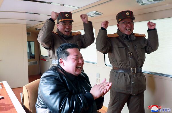 Această fotografie făcută pe 24 martie 2022 și publicată de Agenția Centrală de Știri din Coreea de Nord (KCNA) la 25 martie 2022 arată liderul nord-coreean Kim Jong Un (C) reacționând în timpul operațiunii de lansare de testare a unui nou tip balistic intercontinental. rachetă (ICBM), Hwasongpho-17 a forțelor strategice ale Coreei de Nord înainte de lansarea de test într-o locație nedezvăluită din Coreea de Nord. - Sputnik Moldova-România