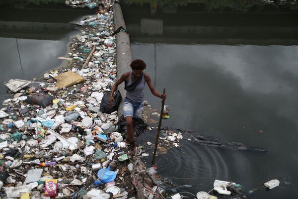 Женщина среди мусора, выброшенного на реку Арройо-Фундо в Рио-де-Жанейро, Бразилия. Снимок сделан во Всемирный день водных ресурсов. - Sputnik Молдова