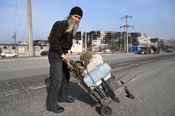 Un bărbat se primblă pe stradă cu un cărucior unde își are lucrurile personale - Sputnik Moldova