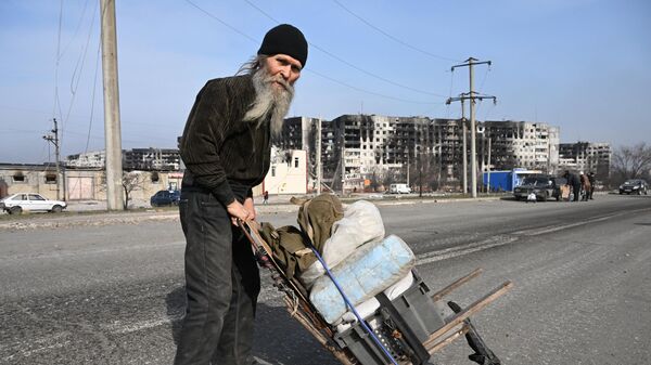 Un bărbat se primblă pe stradă cu un cărucior unde își are lucrurile personale - Sputnik Moldova
