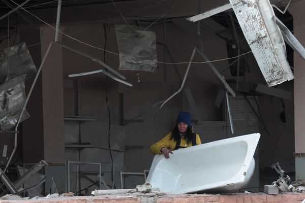 O femeie răscolește sub dărâmăturile unei case prăbușite din Mariupol - Sputnik Moldova