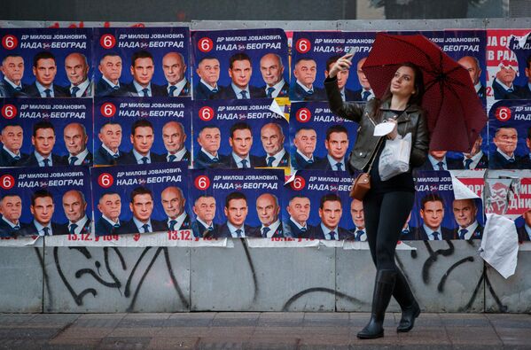 O femeie își face un selfie lângă un afiș de campanie electorală cu Milos Jovanovic, candidatul la președinție al coaliției Nada (Speranța), la Belgrad, Serbia, 31 martie 2022. - Sputnik Moldova-România