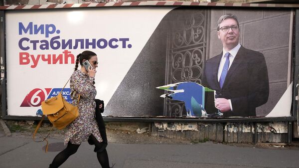 Девушка проходит мимо предвыборного рекламного щита с изображением действующего президента Сербии и лидера Сербской прогрессивной партии Александра Вучича в Белграде, Сербия - Sputnik Молдова