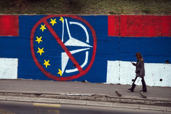 Un pieton trece pe lângă o pictură murală anti-UE și anti-NATO din Belgrad pe 30 martie 2022. - Sputnik Moldova-România