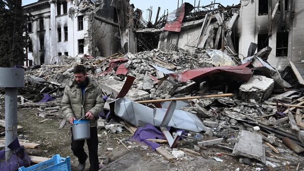 Житель города пришел к колодцу около разрушенного здания Мариупольского драматического театра - Sputnik Молдова