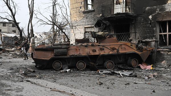 Уничтоженный бронетранспортер БТР-82 у разрушенного жилого дома в Мариуполе - Sputnik Moldova