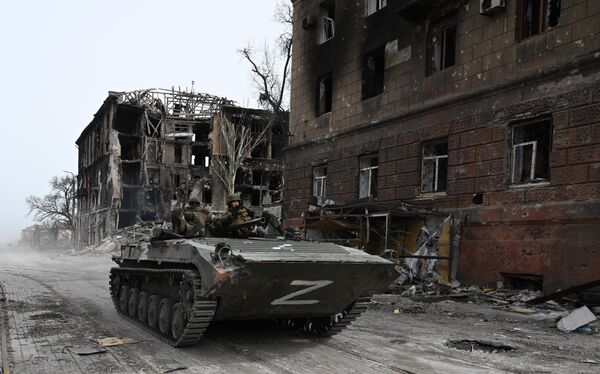 Боевая машина пехоты БМП-1 армии ДНР у разрушенного жилого дома в Мариуполе - Sputnik Молдова