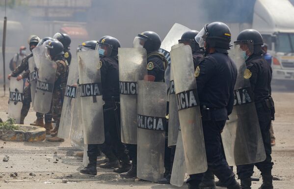 Forțele de menținere a ordinii publice se confruntă cu manifestanți în timpul ciocnirilor care au izbucnit în cadrul unei greve parțiale a transportatorilor de marfă și pasageri, în Ate, un district la est de Lima, pe 4 aprilie 2022. - Sputnik Moldova
