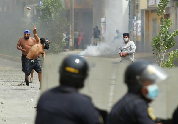 Manifestanții se confruntă cu polițiștii în timpul grevei parțiale a transportatorilor de marfă și pasageri, în Ate, un district la est de Lima, pe 4 aprilie 2022. - Sputnik Moldova