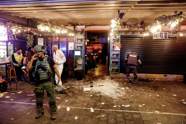Ofițerii israelieni de securitate și echipele de salvare în acțiune la intrarea într-un restaurant, în urma unui incident din Tel Aviv, Israel, 7 aprilie 2022. - Sputnik Moldova-România