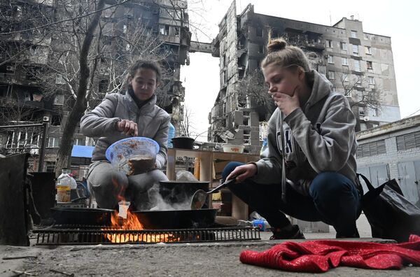 Жители Мариуполя готовят еду во дворе разрушенного дома  - Sputnik Молдова