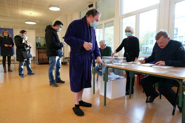 Избиратель в халате и тапочках прибывает на избирательный участок в Реймсе, Франция. - Sputnik Молдова