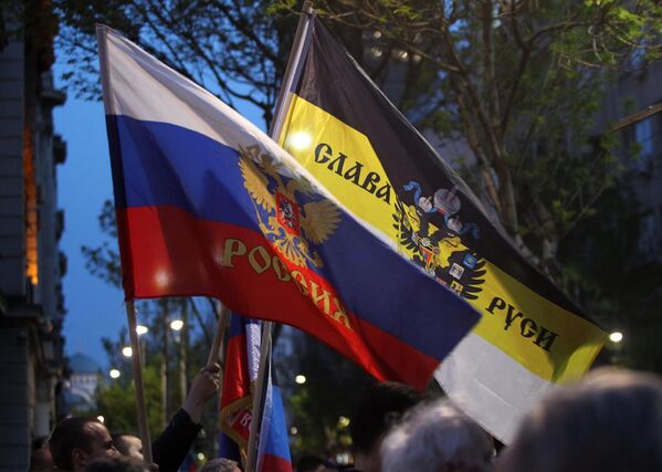 Steaguri în mâinile protestatarilor împotriva impunerii de sancțiuni împotriva Rusiei și împotriva votului Serbiei în ONU împotriva Rusiei, pe una dintre străzile din Belgrad. - Sputnik Moldova-România