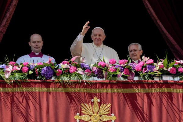 Papa Francisc, în centru, face semn mulțimii de credincioși după tradiționala binecuvântare „Urbi et Orbi” (Către oraș și către lume) la finalul slujbei catolice de Duminica Paștelui pe care a condus-o în Piața Sf. Petru din Vatican, 17 aprilie 2022.  - Sputnik Moldova-România