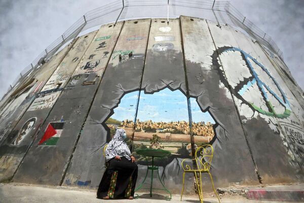 O femeie palestiniană se uită la o pictură murală care înfățișează complexul Moscheei Al-Aqsa și orașul vechi al Ierusalimului - Sputnik Moldova
