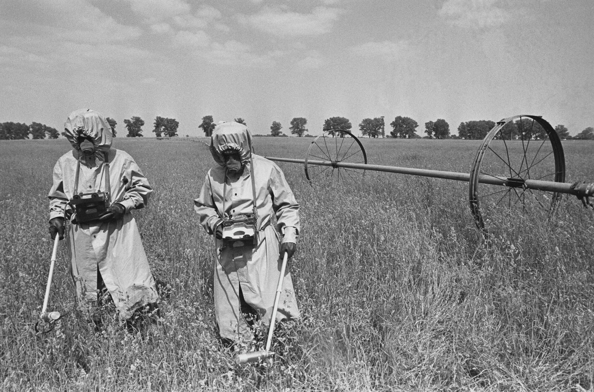 Дозиметристы в специальных костюмах проводят контроль радиации на полях в районе аварии - Sputnik Молдова, 1920, 26.04.2024