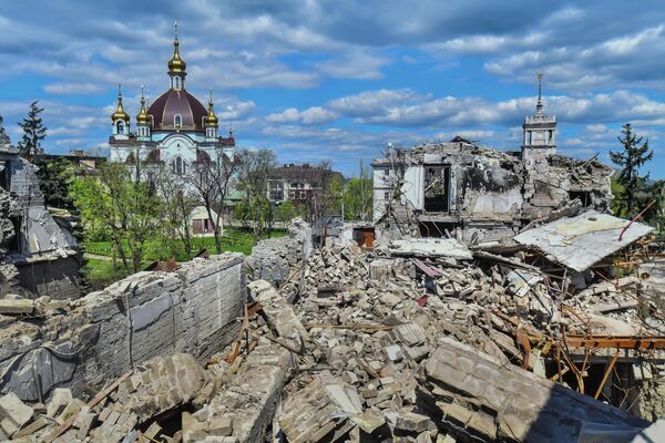 Clădirea distrusă a Teatrului Dramatic Academic Regional Donețk din Mariupol. În stânga este Biserica Mijlocirii Maicii Domnului. - Sputnik Moldova-România