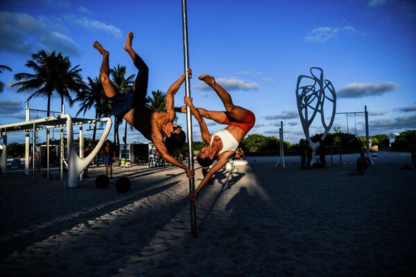 Спортсмены занимаются акробатикой с шестом на песке в Майами-Бич, США. - Sputnik Молдова
