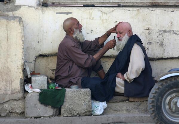 Мужчина бреется у уличного парикмахера в Пешаваре, Пакистан. - Sputnik Молдова