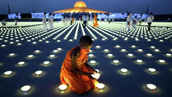 Буддийский монах устанавливает светодиодный светильник в рамках празднования Дня Земли, Таиланд  - Sputnik Молдова