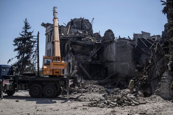 Lucrări de evacuarea a ruinelor care au mai rămas din clădirea distrusă a Teatrului Dramatic Academic Regional Donețk din Mariupol. - Sputnik Moldova