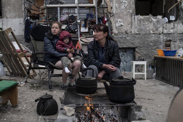 Localnicii fierb apă la foc lângă un bloc de locuit din Mariupol. - Sputnik Moldova