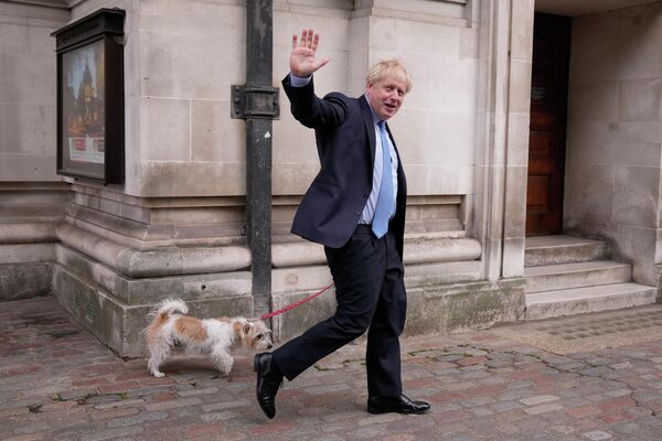 Премьер-министр Великобритании Борис Джонсон со своей собакой после голосования на избирательном участке в Лондоне - Sputnik Молдова