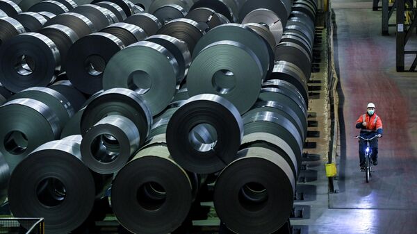 Сотрудник проезжает мимо холоднокатаной стали на рулонах в цеху завода ThyssenKrupp в Дуйсбурге, западная Германия - Sputnik Moldova-România