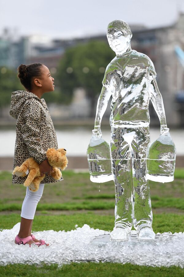 Девочка у ледяной скульптуры, изображающей собирающего воду, в Лондоне. - Sputnik Молдова