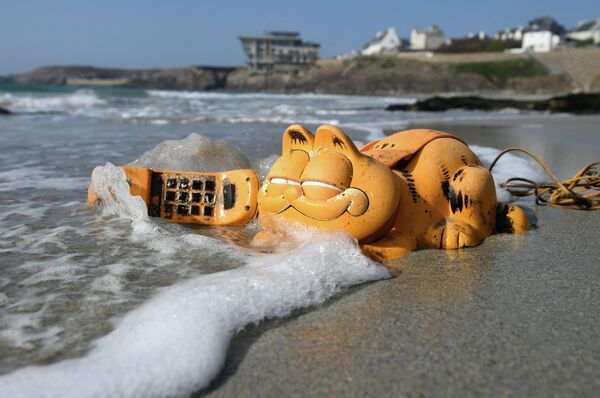 Пластиковый телефон &quot;Гарфилд&quot; на пляже в Ле-Конке, западная Франция. - Sputnik Молдова