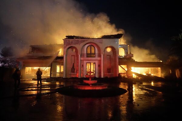 Пожарные тушат строение, горящее во время лесного пожара, в Лагуна-Нигель, Калифорния. - Sputnik Молдова
