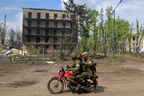 Военнослужащие едут на мотоцикле мимо разрушенных домов в городе Попасная - Sputnik Молдова