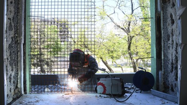 Сотрудник МЧС РФ проводит восстановительные работы в поликлинике на проспекте Мира в Мариуполе - Sputnik Молдова