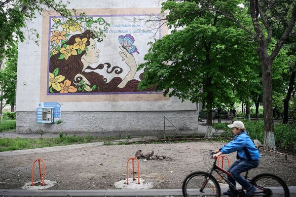 Мальчик едет на велосипеде на одной из улиц в Мариуполе - Sputnik Молдова
